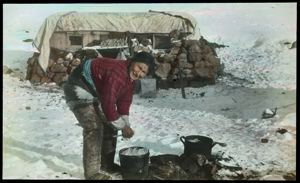 Image of Ane Petersen Cooking Meat Outside Rock-Sod Igloo